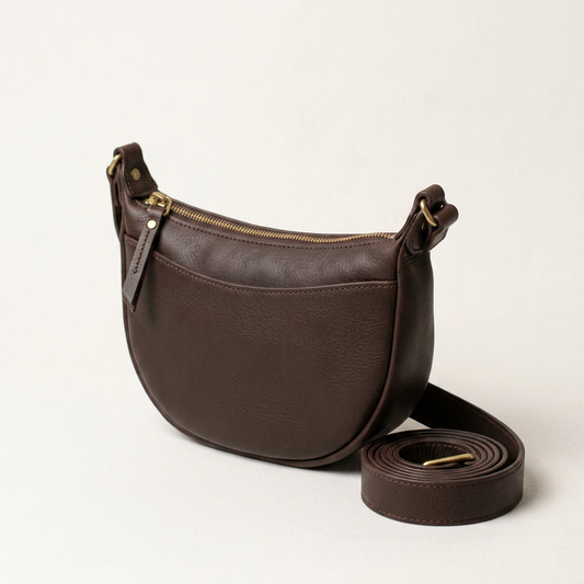 Aldon leather crossbody sling, three-quarter angle with strap coiled beside it