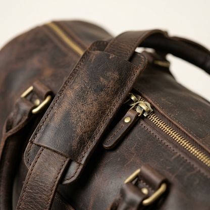 Close-up of brass zip pull and leather handle wrap on the Bramwell duffle